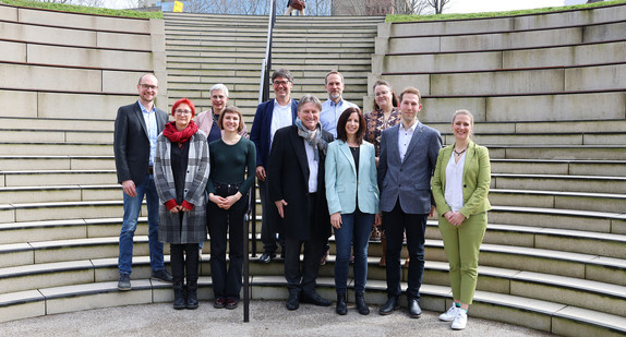 Gruppenbild auf Treppe vor Landtag Baden-Württemberg: Sozialminister Manne Lucha mit Vertreterinnen und Vertretern der sechs „Housing First“-Modellprojekte.